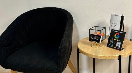 Área de espera acolhedora no Cris Ferraz Beauty em Sydney, New South Wales, AU com poltrona e mesa decorativa.