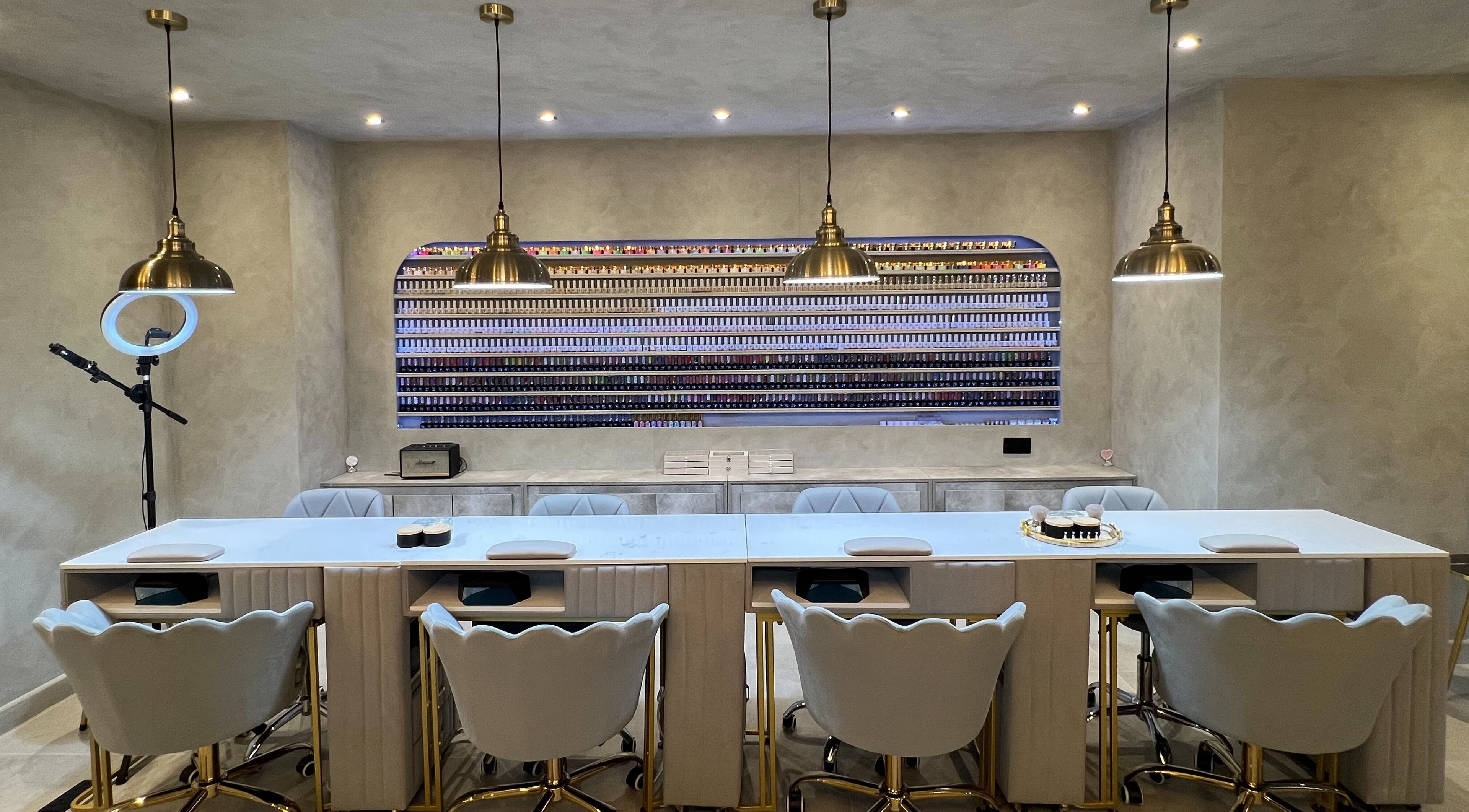 Stylish nail bar at NAIL X in Leeds, England featuring chic seating and a vast nail polish display.