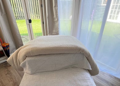 Relaxing treatment room at Serene Skin Solutions in Carluke, Scotland, GB with a massage table and garden view.