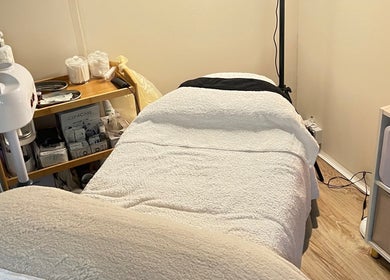 Cozy treatment room at Serene Skin Solutions, Carluke, Scotland, GB with a comfortable bed and skincare products.