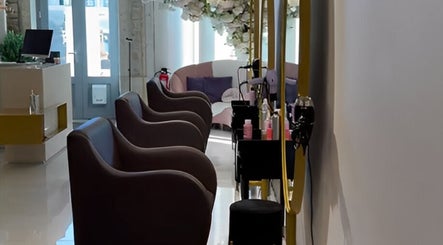 Interior do Albacoa Salon em Viana Do Castelo, PT, com elegantes cadeiras e decoração floral.