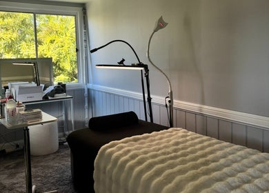Cozy treatment room at Enchanted Beautique, Coopers Plains, Queensland, AU with plush bed and soft lighting.