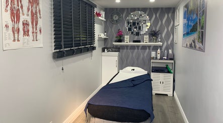 Relaxing treatment room at J.F Muscle Medic, Stourbridge, England, GB with a massage table and calm decor.