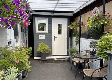 Charming entrance of J.F Muscle Medic adorned with vibrant flowers in Stourbridge, England, GB.