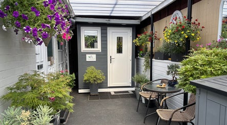 Charming entrance of J.F Muscle Medic adorned with vibrant flowers in Stourbridge, England, GB.