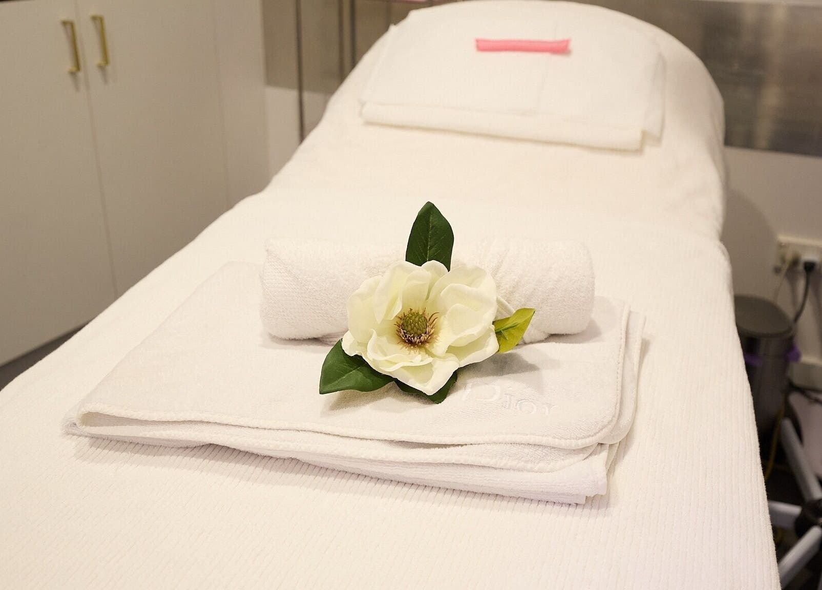 Relaxing spa setup with white towels and flower at Beauty Circle, Sydney, New South Wales, AU.