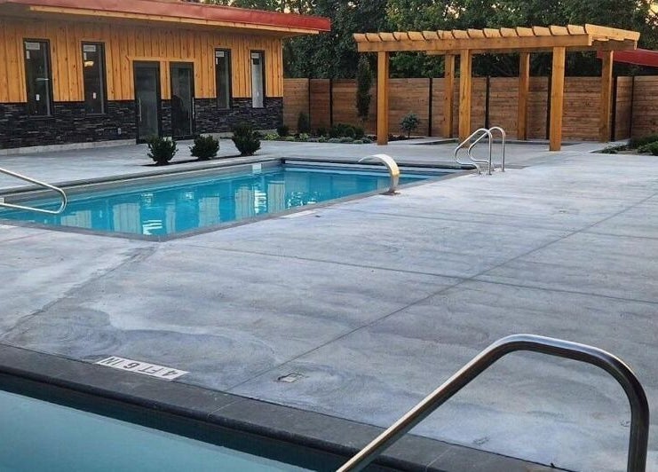 Modern outdoor pool setting at Wave Nordic Spa, Mount Elgin, Ontario, CA with wooden elements and clear water.