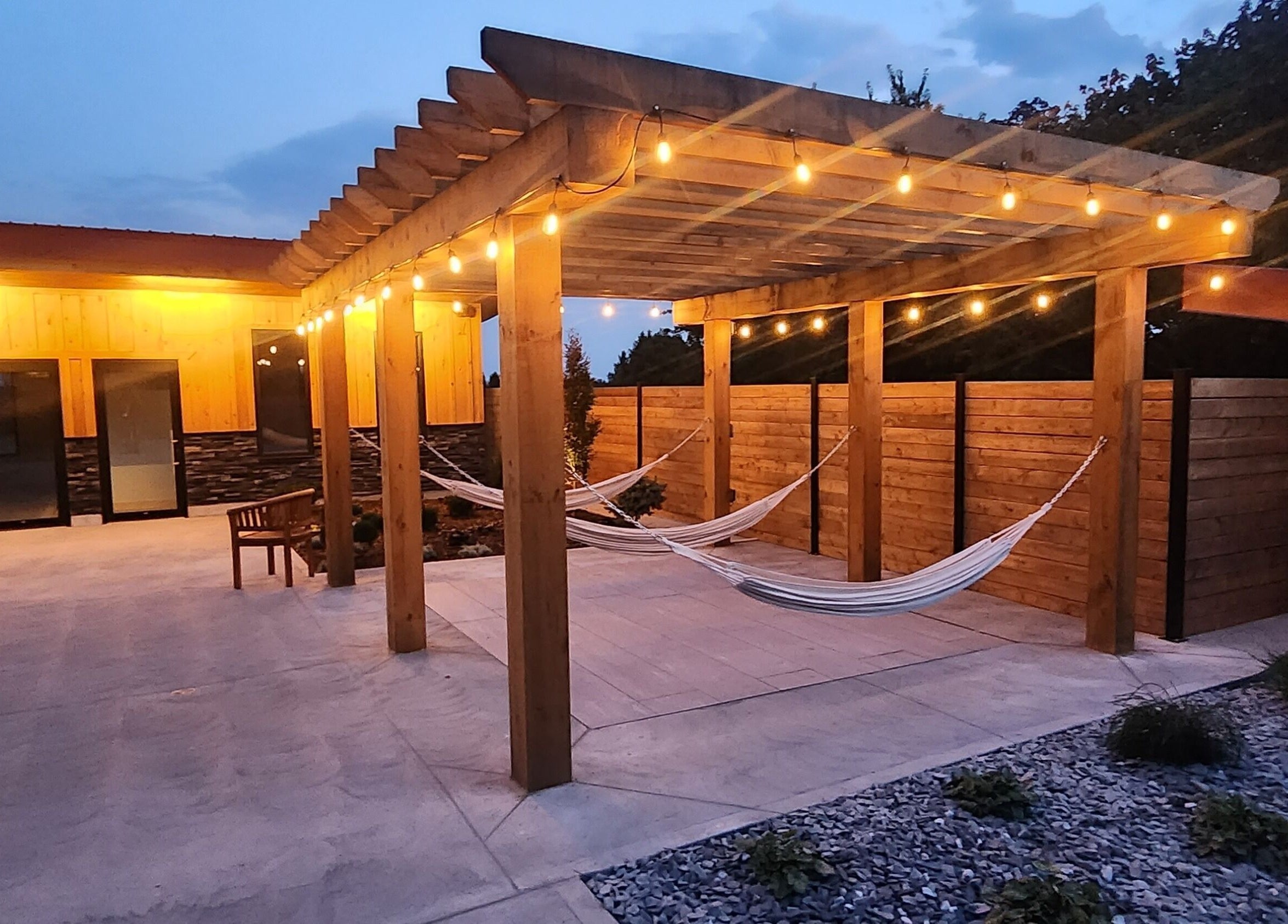 Outdoor hammocks under a lit pergola at Wave Nordic Spa, Mount Elgin, Ontario, CA.