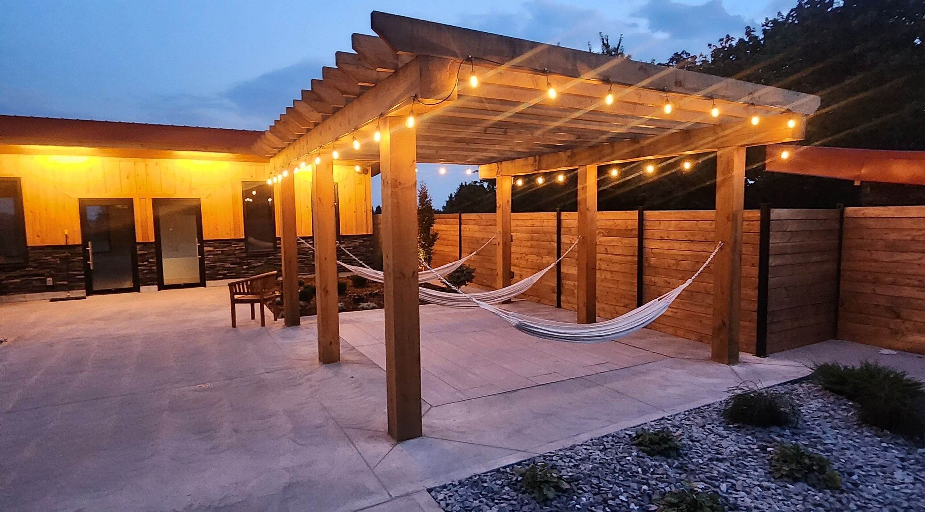 Outdoor hammocks under a lit pergola at Wave Nordic Spa, Mount Elgin, Ontario, CA.