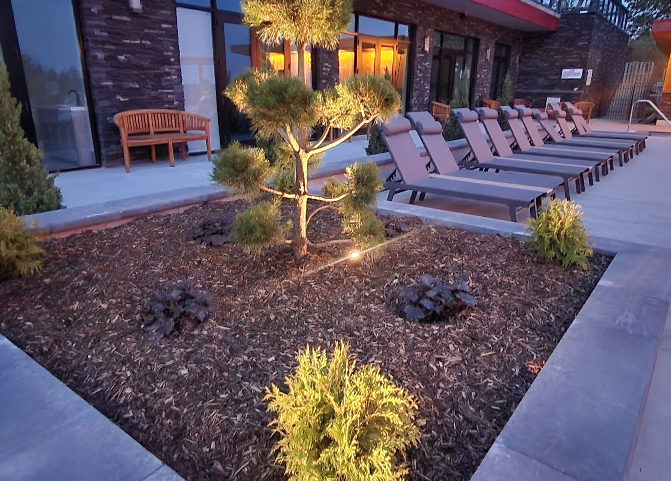 Tranquil outdoor seating at Wave Nordic Spa in Mount Elgin, Ontario, CA, with elegant landscaping.