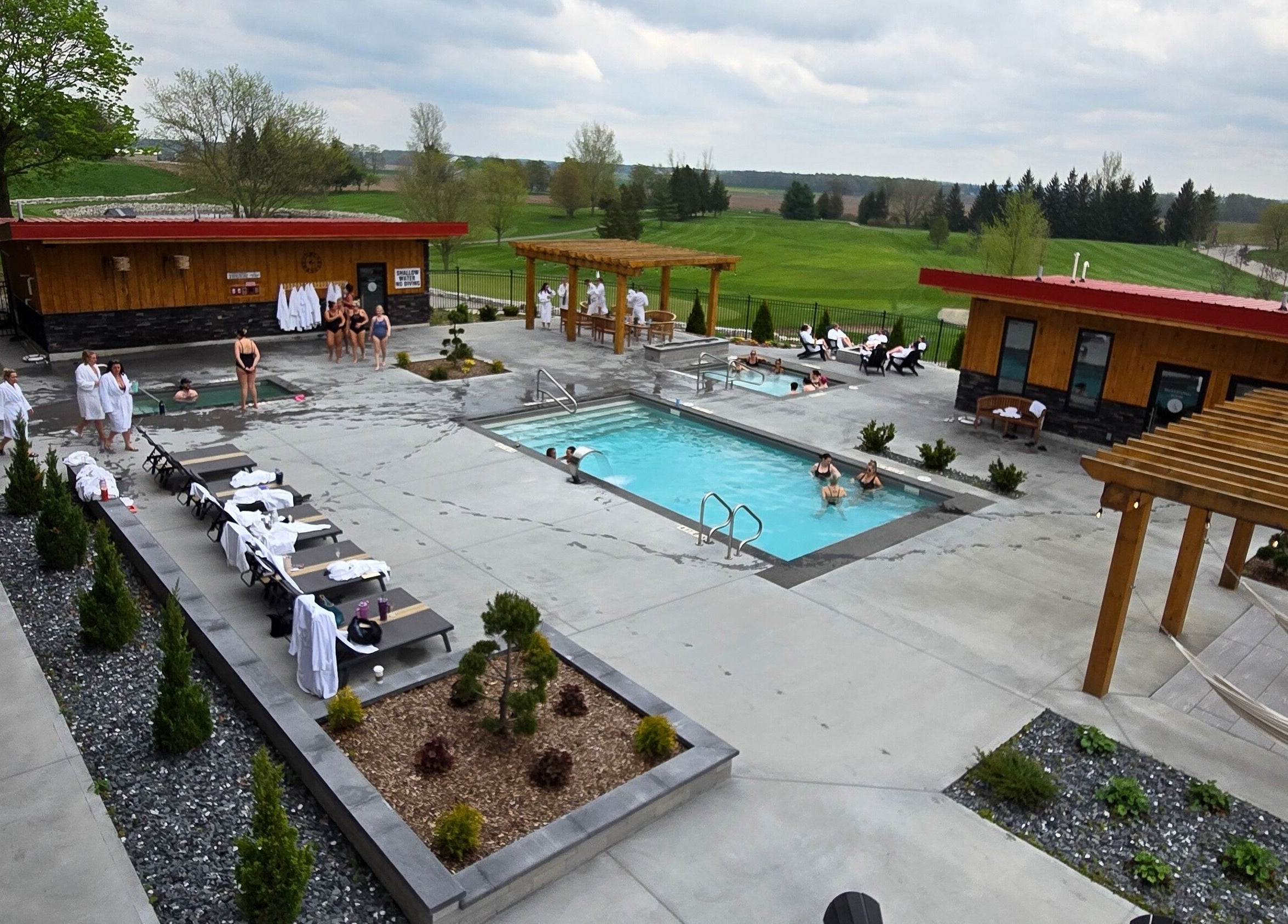 Outdoor pools and relaxation spaces at Wave Nordic Spa, Mount Elgin, Ontario, CA with guests enjoying tranquil views.