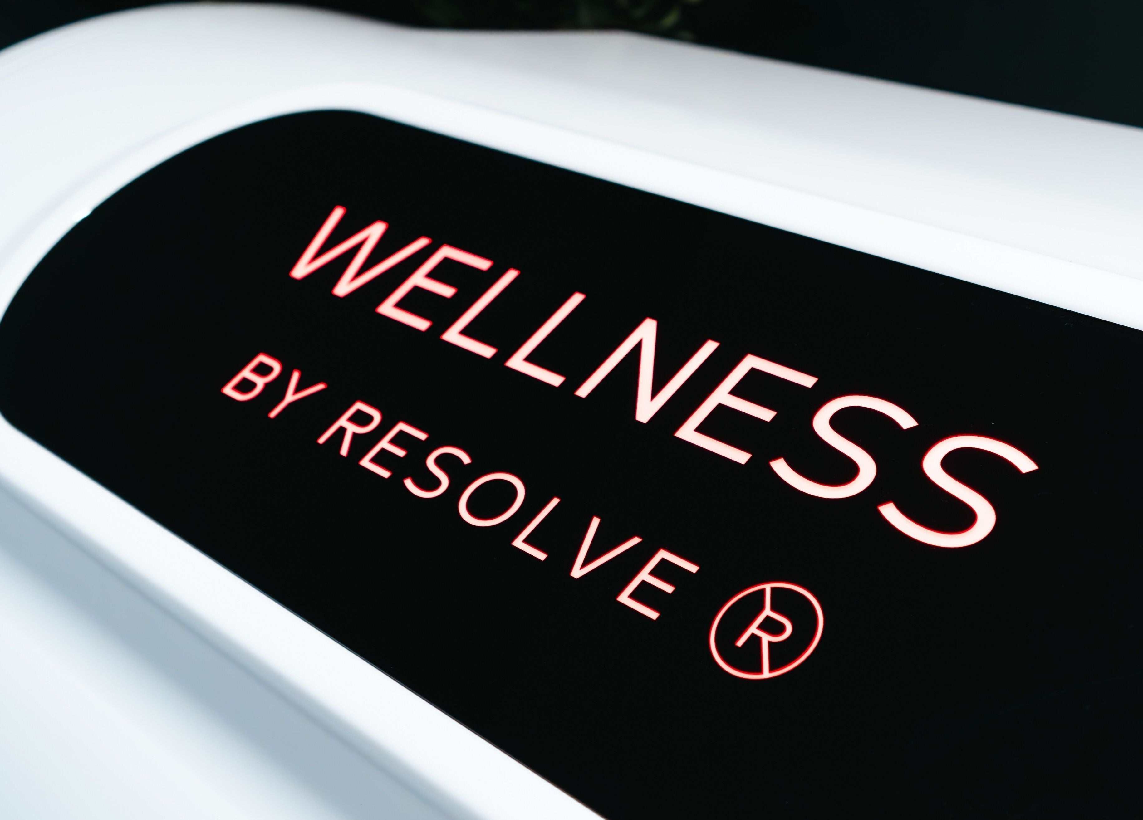 Illuminated Wellness By Resolve sign in Birmingham, England, GB highlighting wellness services.