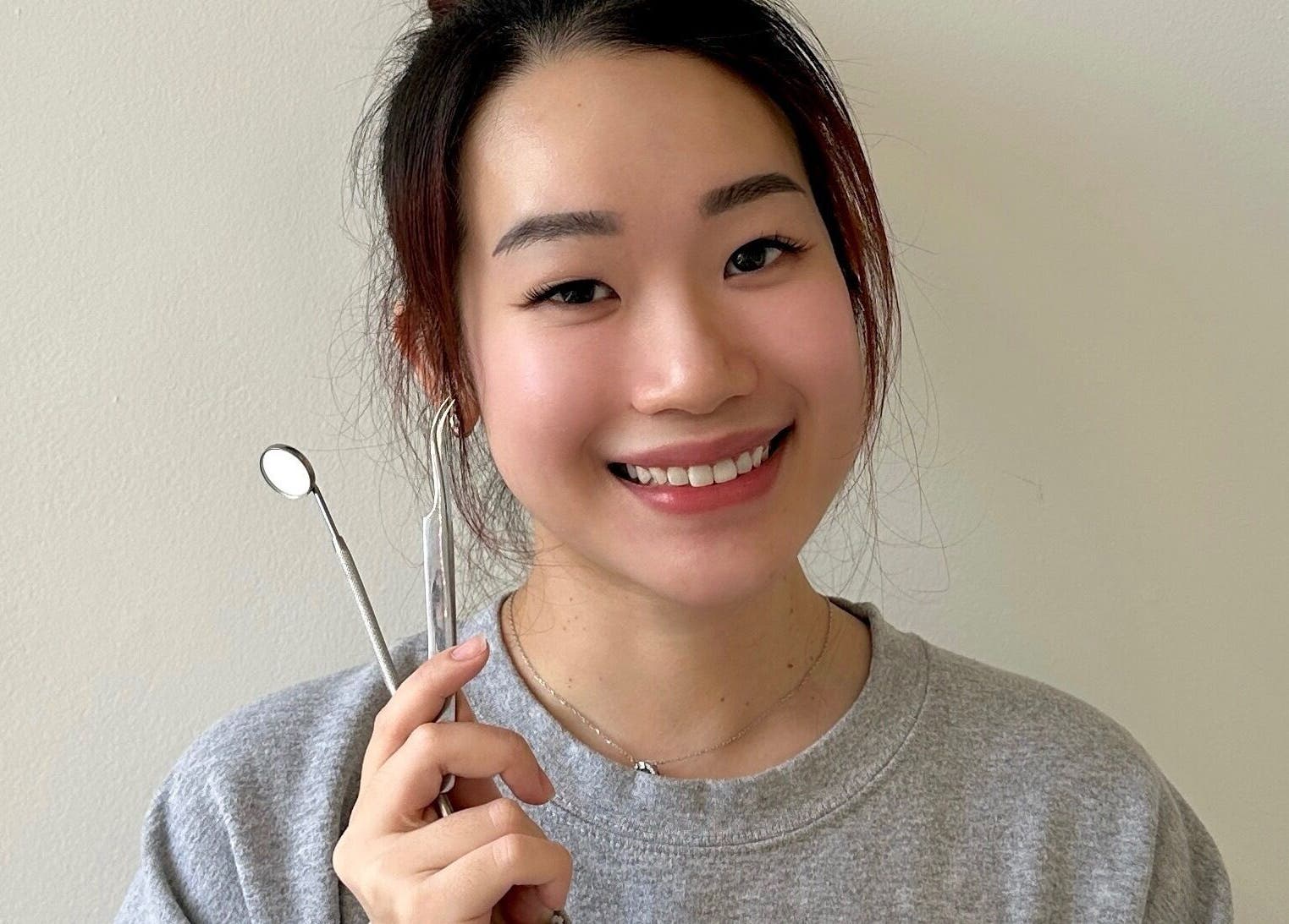 Smiling person holding beauty tools at Blinkwzoe, Burnaby, British Columbia, CA.