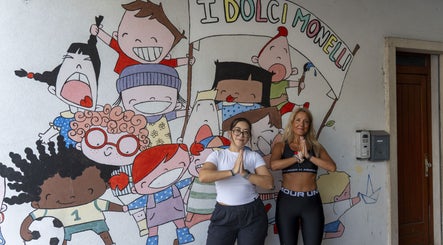 Due persone in posa yoga davanti a murale colorato presso NAYOGA, Creazzo, Veneto, IT.