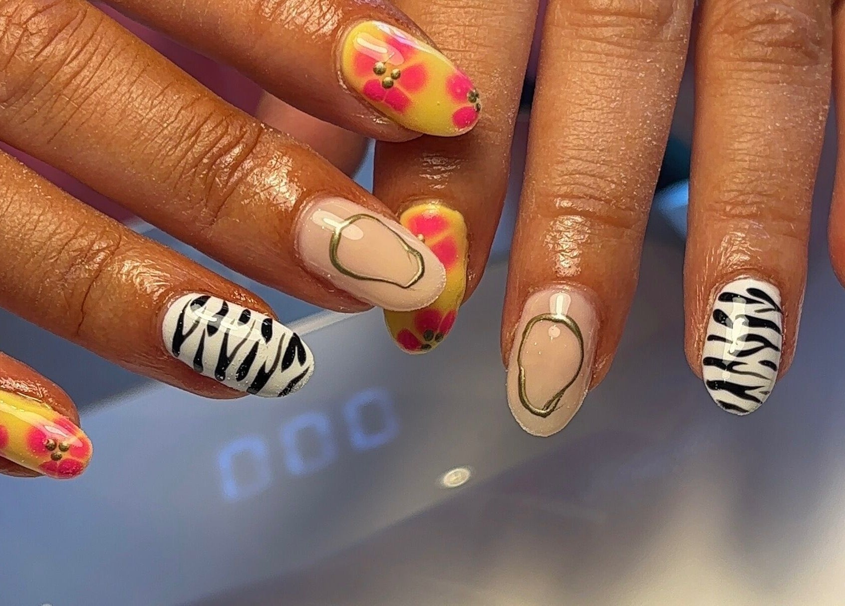 Colorful nail art at Beauty By Katie Davies, Neath, Wales, GB showcasing floral and zebra designs.