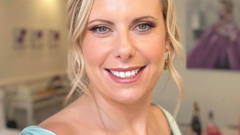 Smiling woman at Dan Campbell Makeup, Glasgow, Scotland, GB, showcasing elegant beauty in a serene setting.
