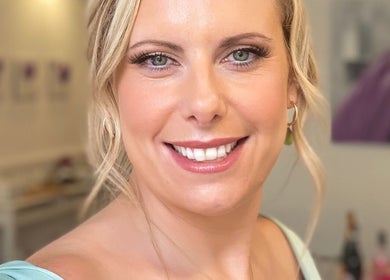 Smiling woman at Dan Campbell Makeup, Glasgow, Scotland, GB, showcasing elegant beauty in a serene setting.