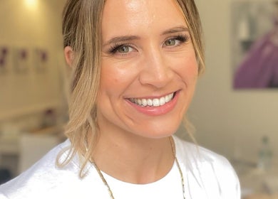 Smiling woman in a white room at Dan Campbell Makeup, Glasgow, Scotland, GB.