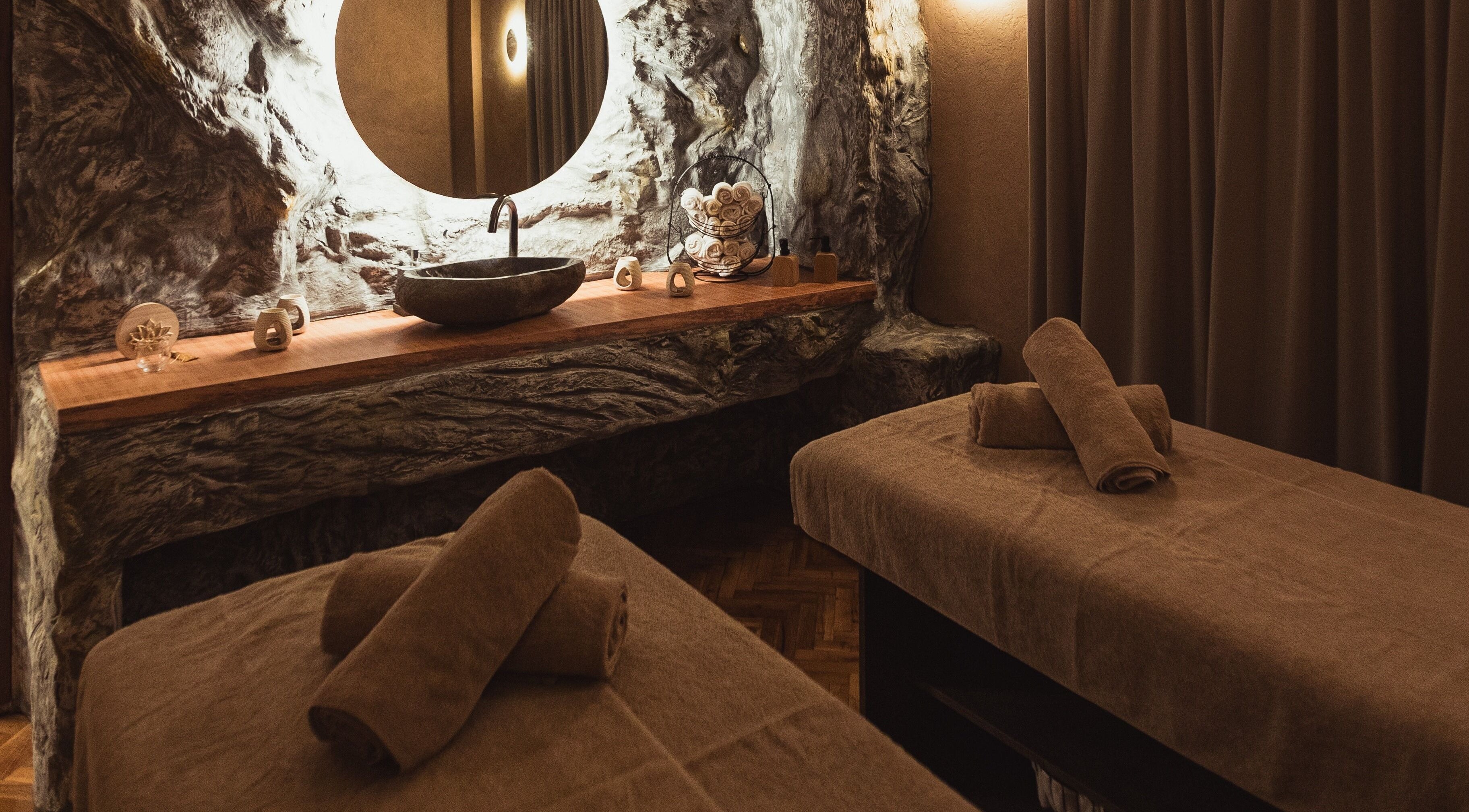 Δραματικός χώρος μασάζ στο Anma The Massage Boutique, Θεσσαλονίκη, GR, με πέτρινο νιπτήρα και χαλαρωτική διακόσμηση.