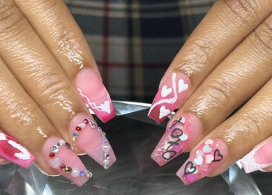 Creative pink nail art at PurpLust Nails, Hazelwood, Missouri, US with hearts and gems.