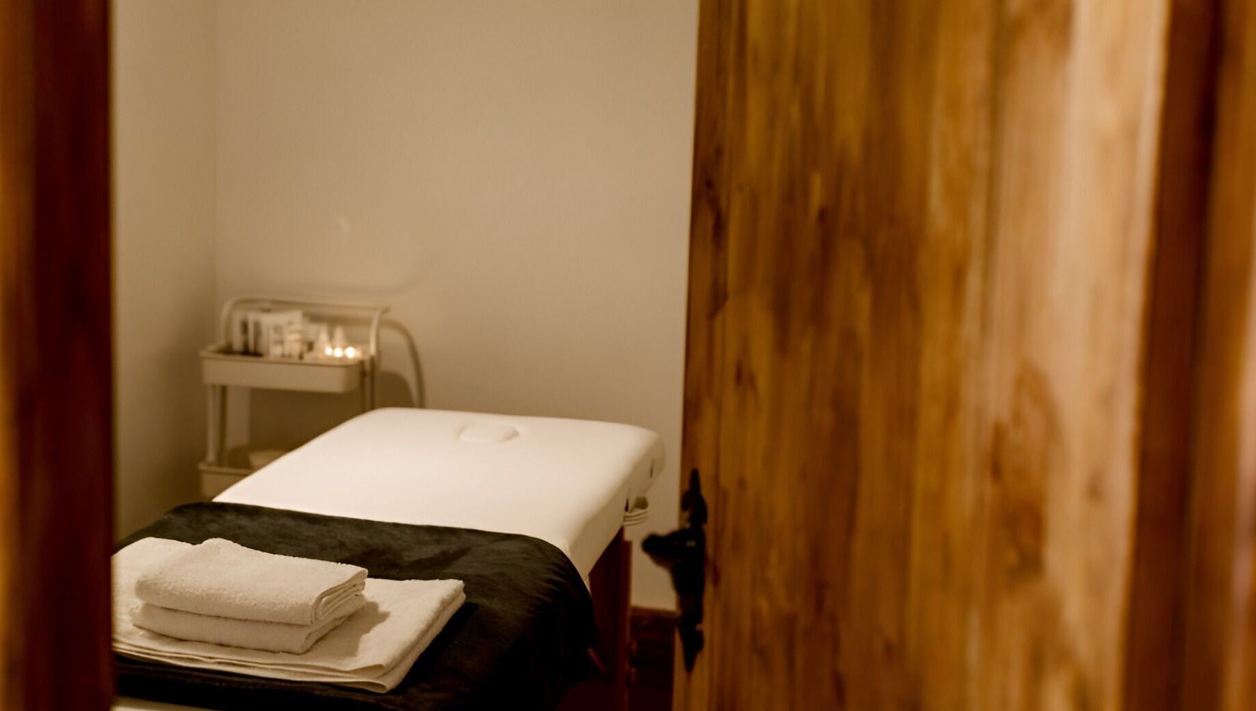 Cozy massage room at Manor Farm Spa - Wellness Lounge in Thorpe Audlin, England, GB with soft lighting and towels.