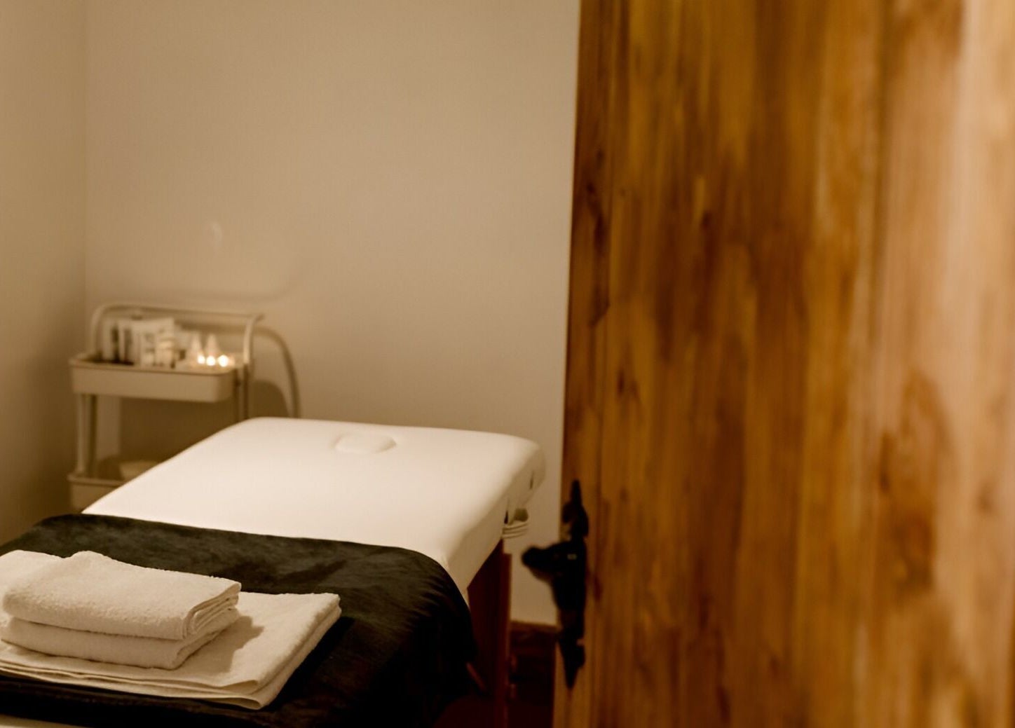 Cozy massage room at Manor Farm Spa - Wellness Lounge in Thorpe Audlin, England, GB with soft lighting and towels.