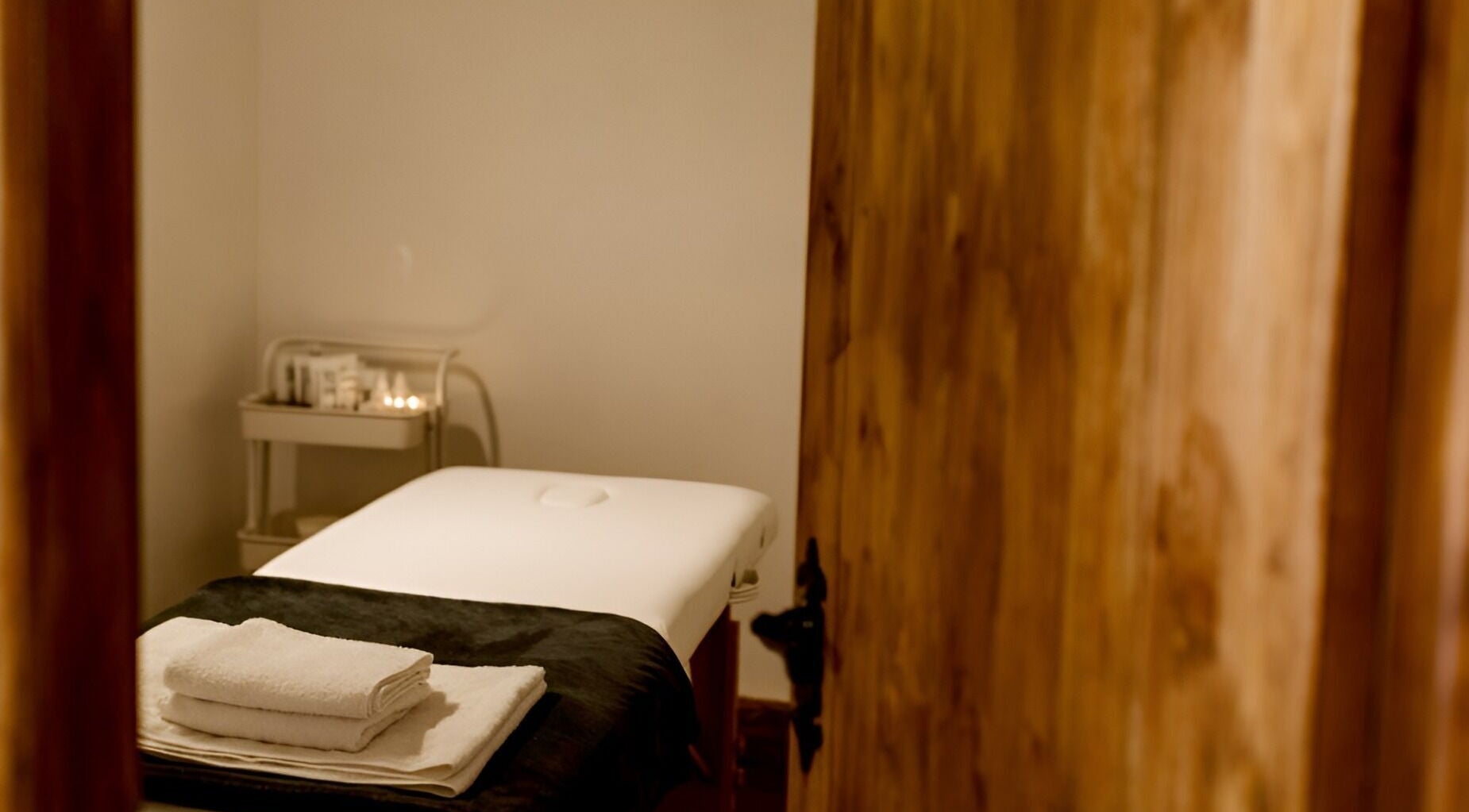 Cozy massage room at Manor Farm Spa - Wellness Lounge in Thorpe Audlin, England, GB with soft lighting and towels.