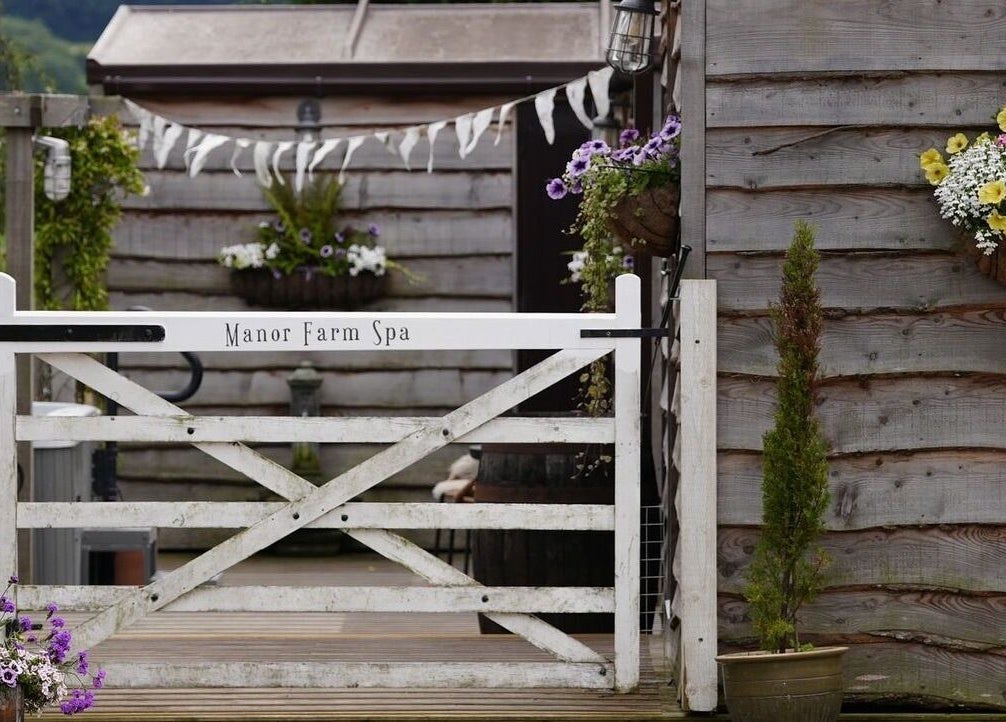 Entrance gate at Manor Farm Spa - Wellness Lounge in Thorpe Audlin, England, GB with flowers and rustic decor.