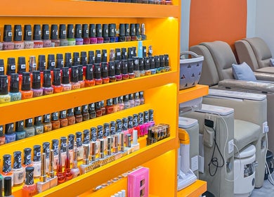 Vibrant nail polish display at Shimmer & Shine at Northpoint, Singapore, SG with comfortable pedicure chairs.