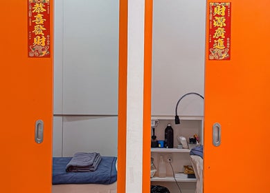 Bright orange sliding doors at Shimmer & Shine at Northpoint in Singapore, Singapore, SG open to a serene spa room.