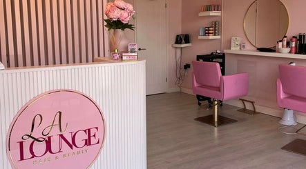 Chic interior of HairbyIssy Howard in Ferndown, England with pink chairs and stylish decor.