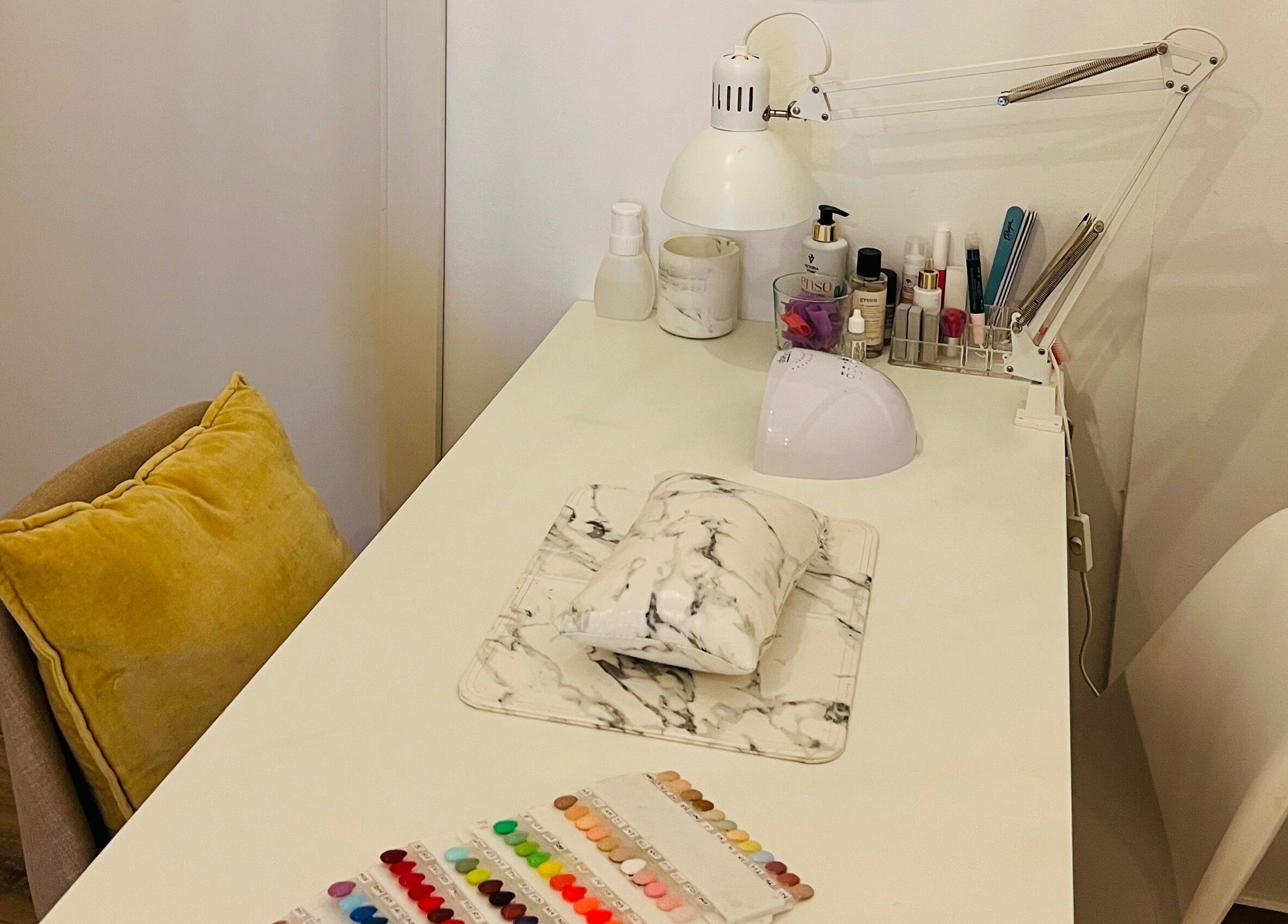 Modern nail station setup at TOV Organic Salon, Tas-sliema, MT, showcasing tools and vibrant nail colors.