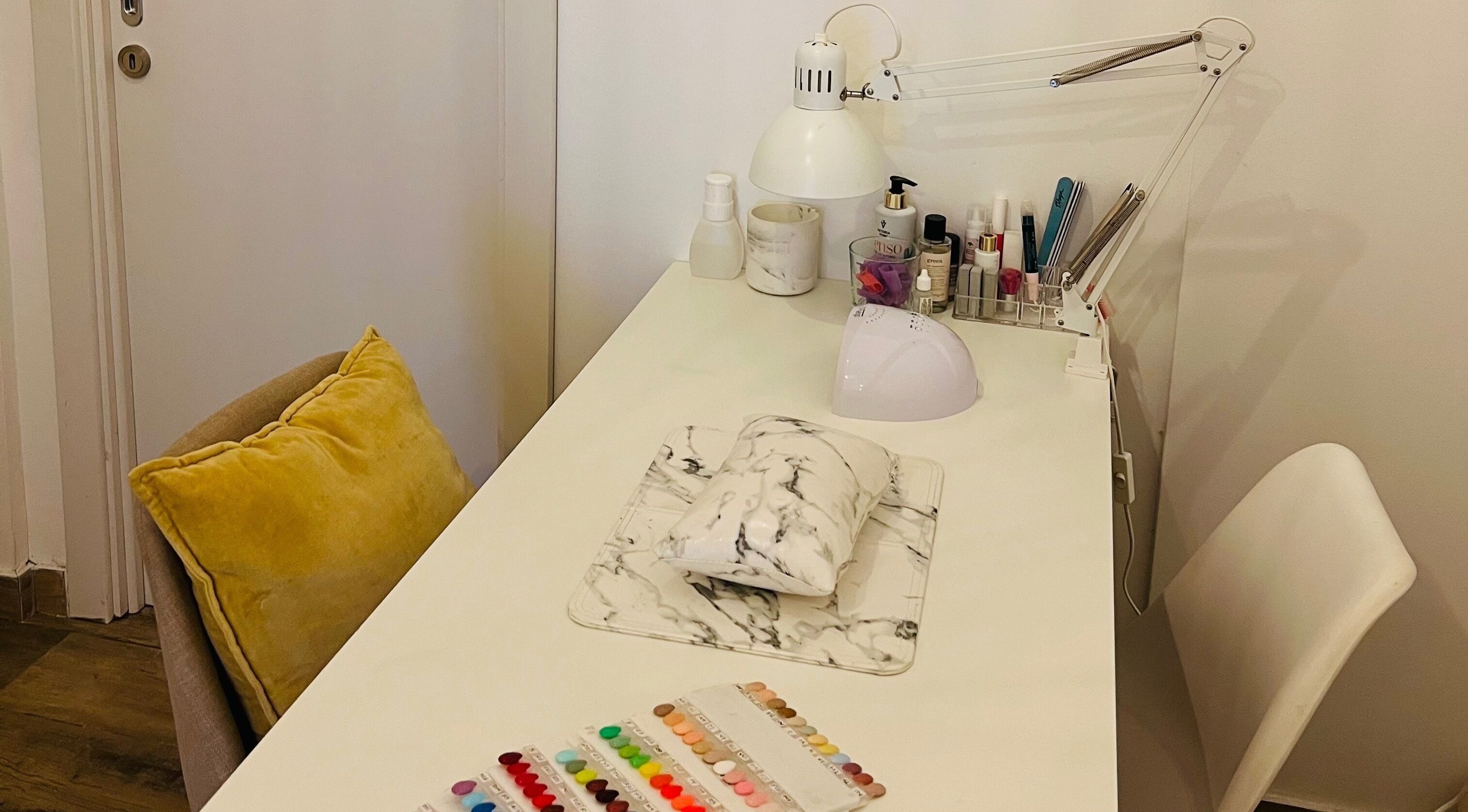 Modern nail station setup at TOV Organic Salon, Tas-sliema, MT, showcasing tools and vibrant nail colors.