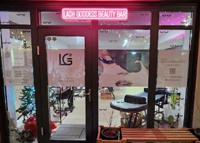 Entrance of Lash Goddess Beauty Bar in Coquitlam, BC, CA with a glowing pink sign.