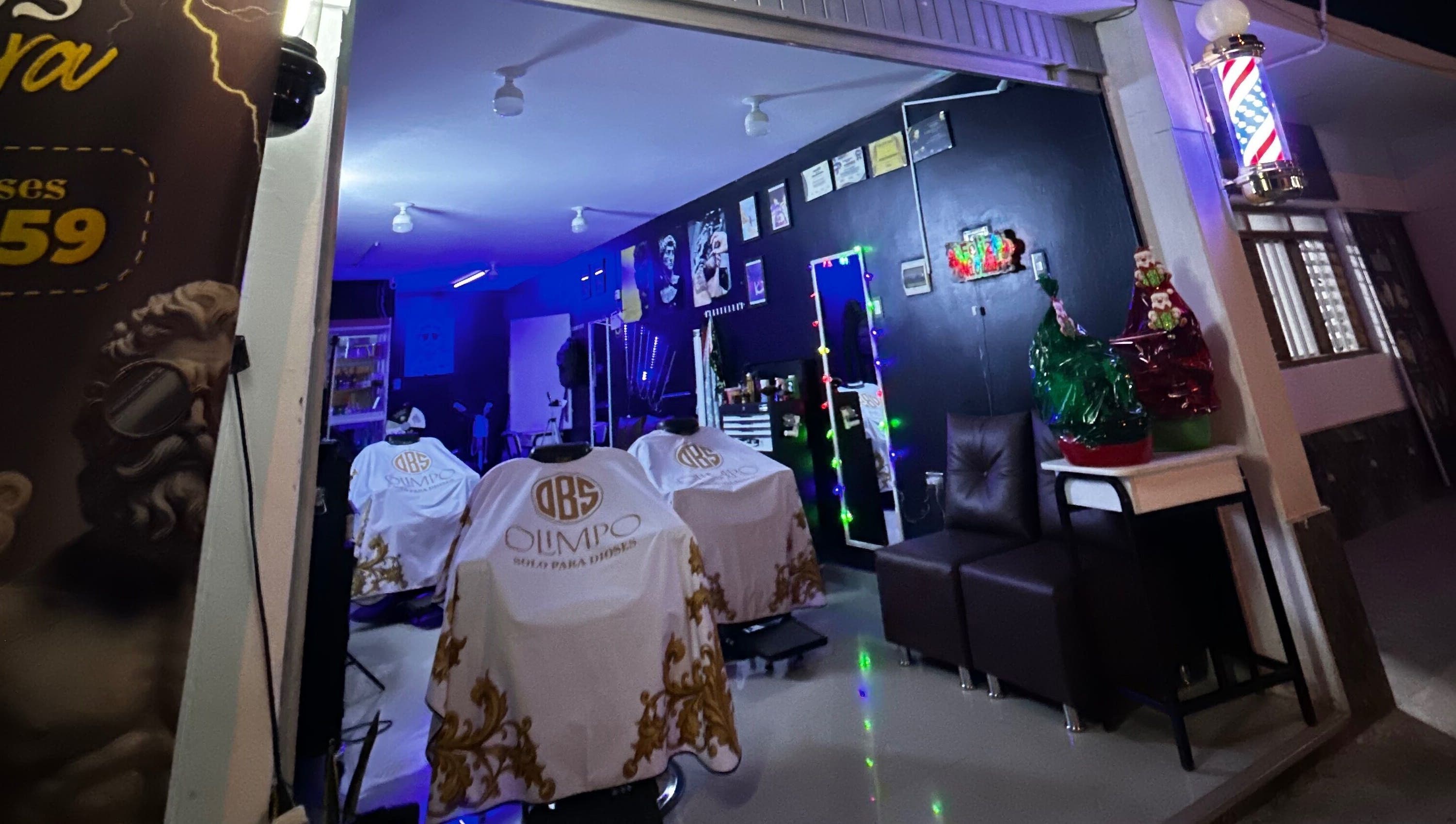 Interior del Olimpo barber studio en Chimbote, Áncash, PE, mostrando sillas de barbería blancas y decoración moderna.