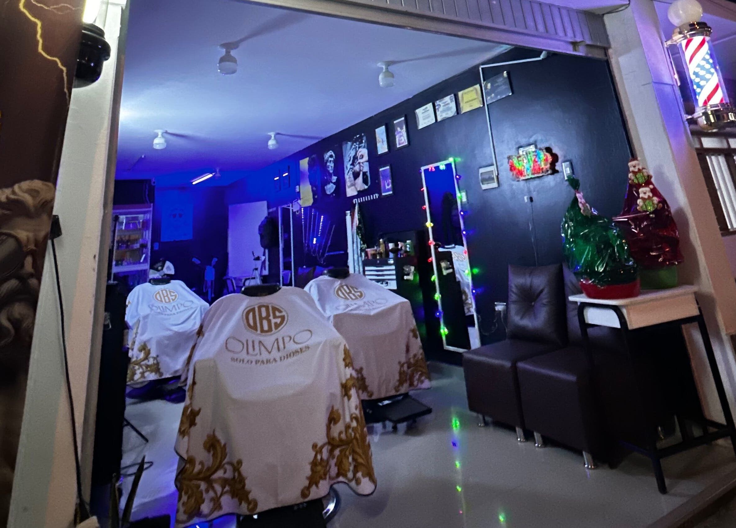 Interior del Olimpo barber studio en Chimbote, Áncash, PE, mostrando sillas de barbería blancas y decoración moderna.