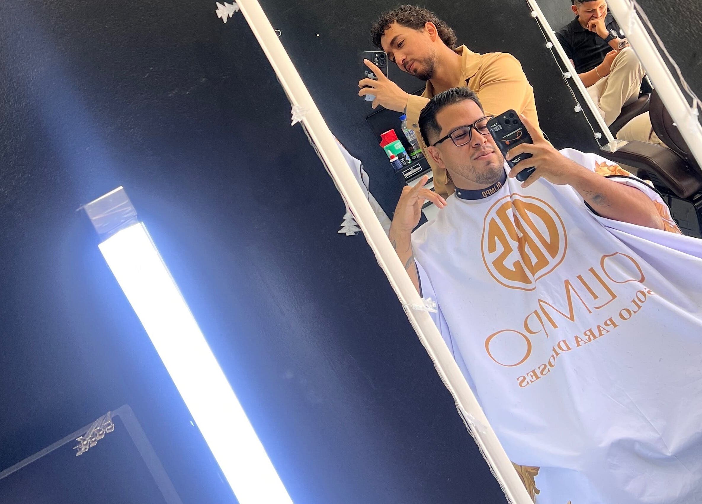 Cliente en Olimpo barber studio disfrutando de un corte profesional en Chimbote, Áncash, PE.