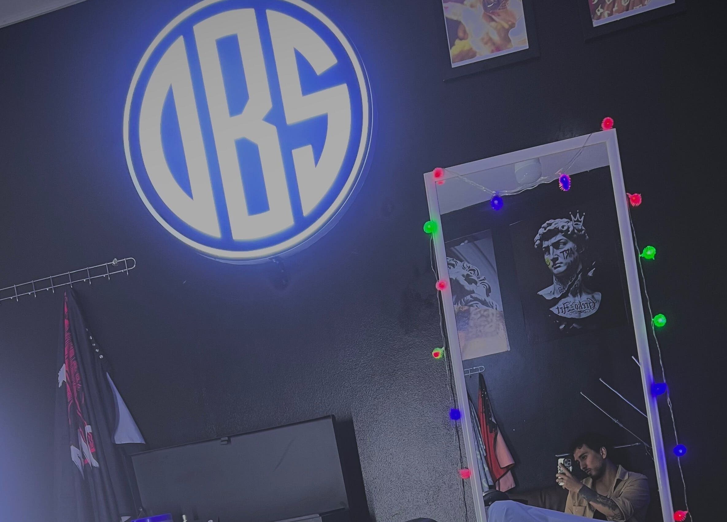 Interior moderno de Olimpo barber studio en Chimbote, Áncash, PE con iluminación neón y decoraciones artísticas.