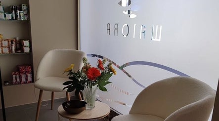 Interno accogliente di Waiora Estetica & Benessere a Tuglie, Puglia, IT con sedie e fiori.