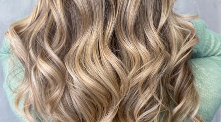 Elegant wavy blonde hair styled at Asha The Hair Lounge, London, GB, showcasing vibrant highlights.