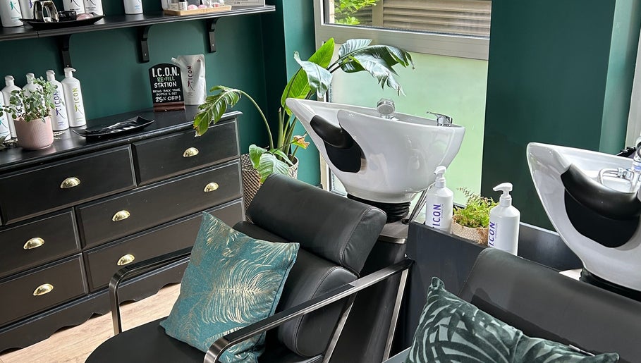 Chic hair washing stations at Asha The Hair Lounge in London, GB featuring modern black furnishings and lush plants.