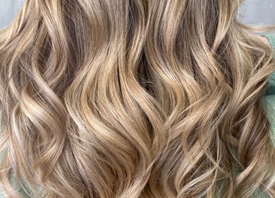 Long, wavy blonde hair styled at Asha The Hair Lounge, London, GB, showcasing expert craftsmanship and color.