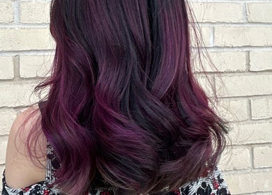 Elegant purple wavy hairstyle from Asha The Hair Lounge in London, GB, showcasing vibrant hair color.