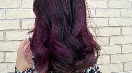 Elegant purple wavy hairstyle from Asha The Hair Lounge in London, GB, showcasing vibrant hair color.