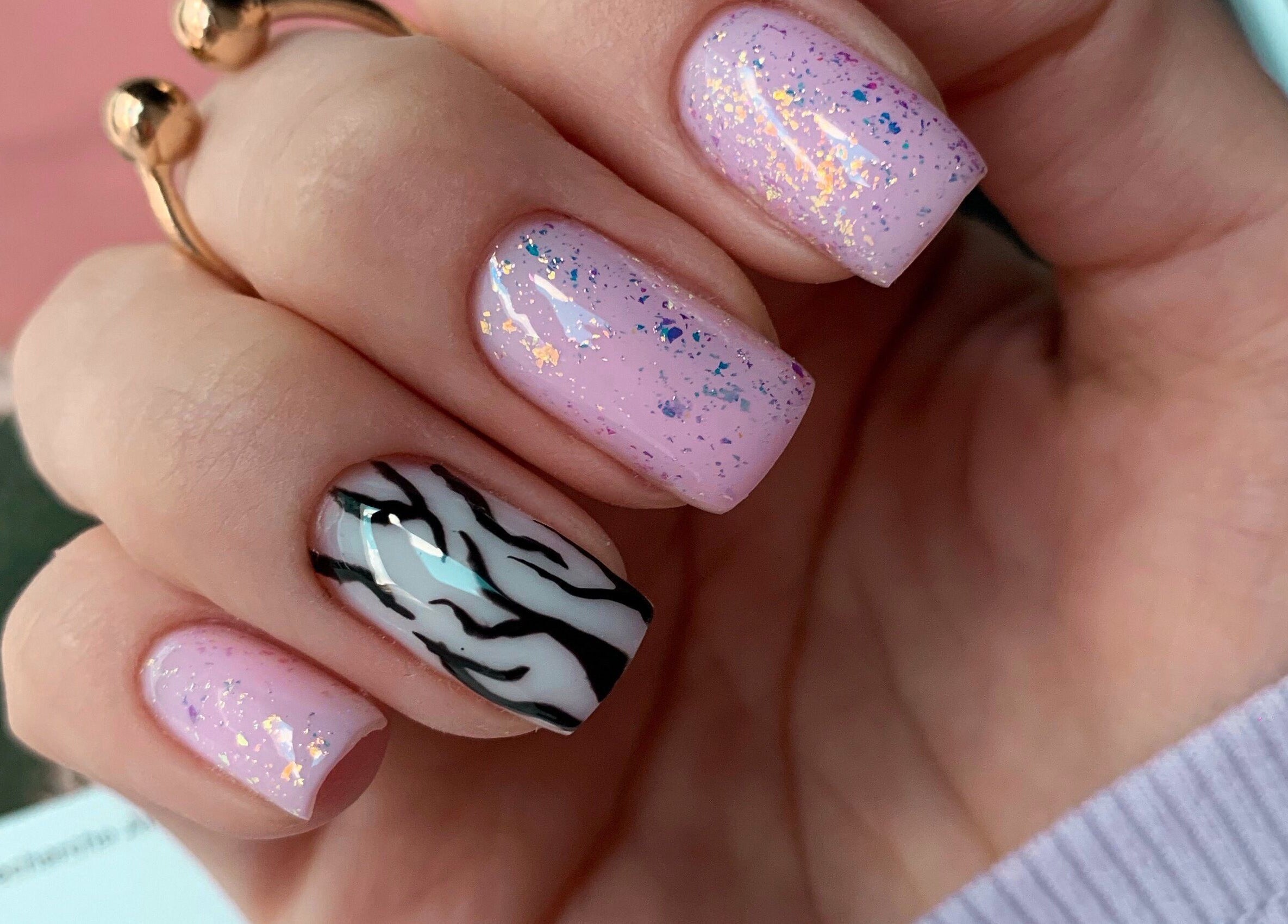 Stylish nail art at Pink Lemonade Beauty Plaza, Key West, Florida, US, featuring pink glitter and zebra stripes.