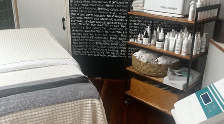 Treatment room at Glow by Daisy, Crabtree, England, GB with bed, towel warmer, and skincare products.