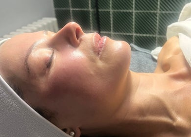 A relaxed client enjoys a facial treatment at Glow by Daisy in Crabtree, England, GB.