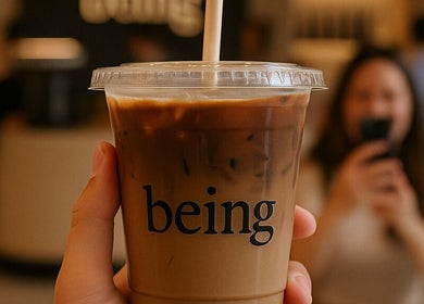 Iced coffee cup with 'Being' logo at Being | Bryanston in Sandton, Gauteng, ZA.