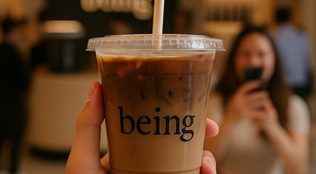 Iced coffee cup with 'Being' logo at Being | Bryanston in Sandton, Gauteng, ZA.
