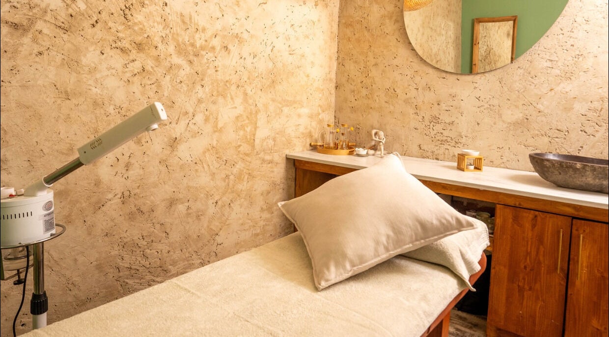Cozy treatment room at being | Morningside, Sandton, Gauteng, ZA featuring a massage table and ambient lighting.